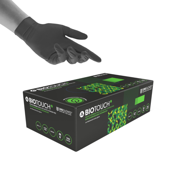 Une main gantée de noir survole une boîte de 100 gants biodégradables Unigloves BioTouch Nitrile, taille moyenne, avec motif noir et vert.