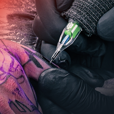 Een close-up van een vinger die wordt getatoeëerd.